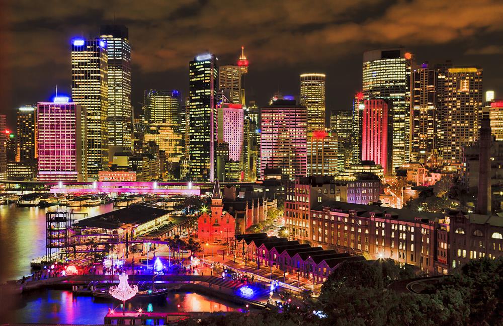 Sydney city CBD towers on Circular quay waterfront of Sydney harbour with bright colourful illumination during annual Vivid sydney light show and festival.
